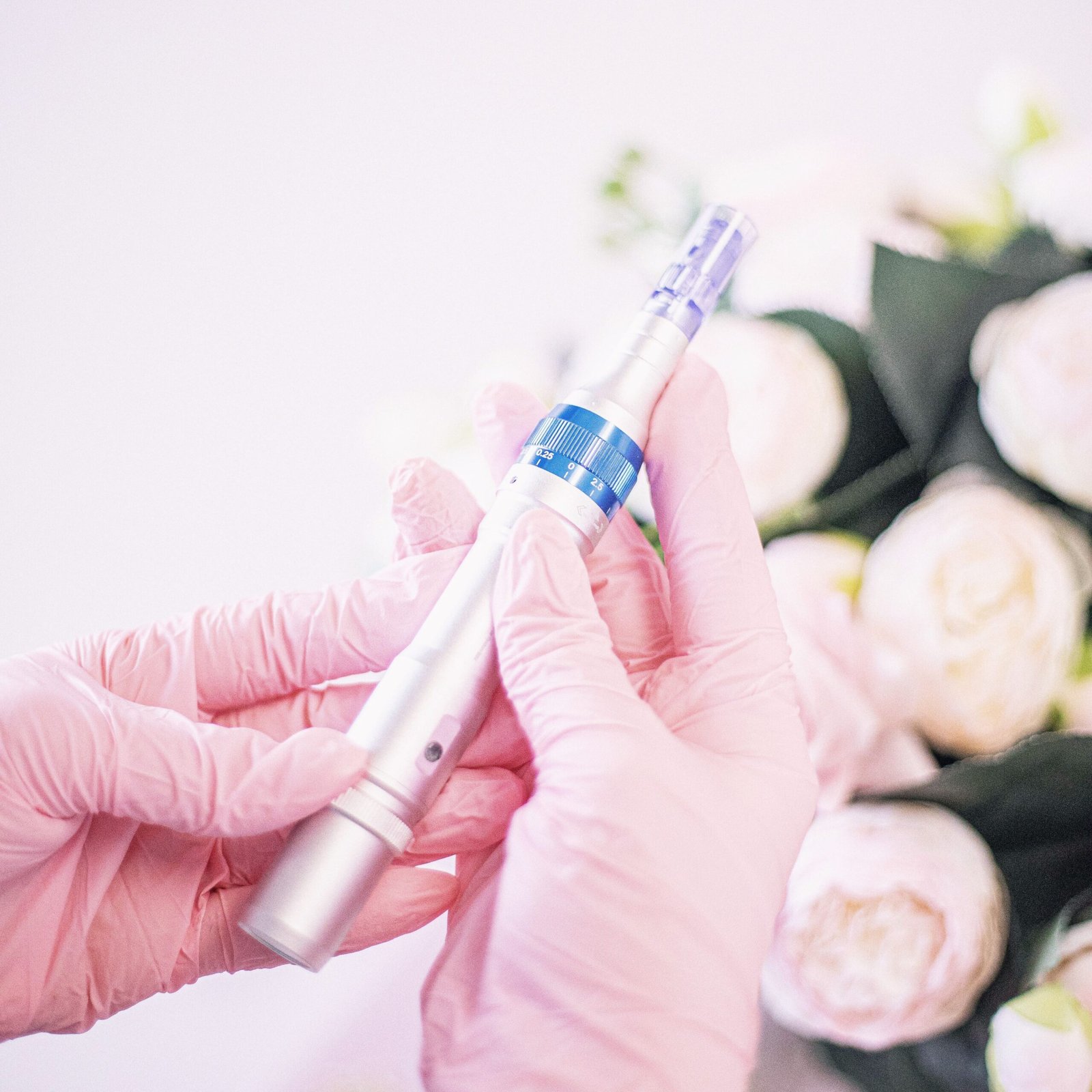 Close-up of hands holding a micro-needling pen, highlighting its use in modern aesthetic treatments.